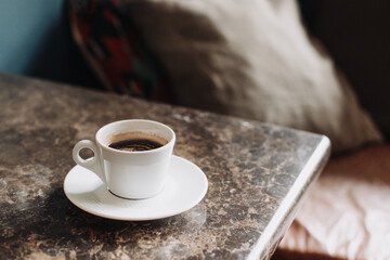 Cup of black coffee on a table in a cafe. Selective focus.