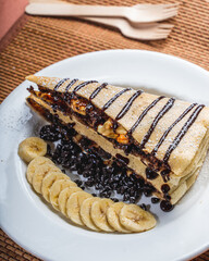 crepe with chocolate filling and banana and blue berries around it