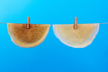 pancakes with clothespins hanging on a rope on a blue background