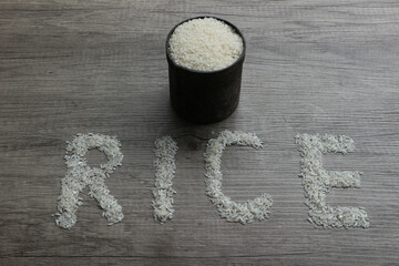 Rice, rice grains form RICE lettering on the wooden background
