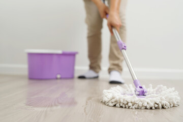 Employees use mop cloths to clean the floor inside the house.