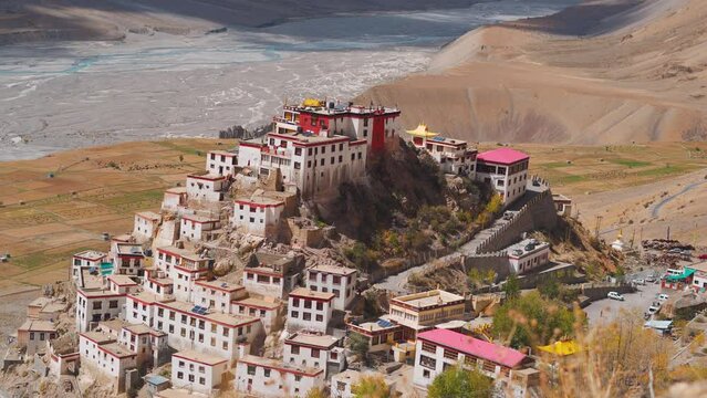 4K high angle shot of the Key monastery from the mountain besides it at Kaza in Spiti Valley, Himachal Pradesh, India. Key gompa in front of the river during the sunny day, Monastery background.