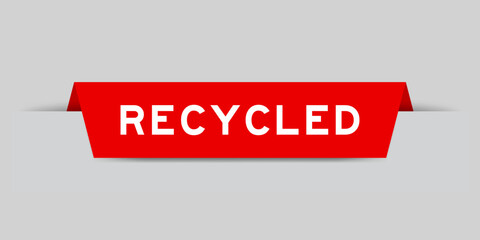 Red color inserted label with word recycled on gray background