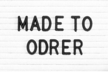 Black color letter in word made to order on white felt board background