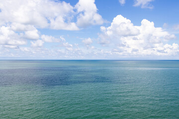 Obraz premium Beautiful calm turquoise color sea and blue sky with white color cloud background