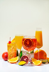 Summer fruit and citrus cocktails for party, low alcohol refreshing drinks with wine, champagne and rum. Beige background, hard light, shadow pattern