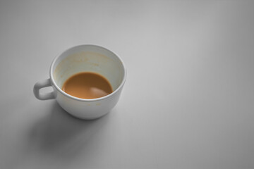 Leftover coffee in ceramic mug standing on wooden table. Coffee break and relax concept.
