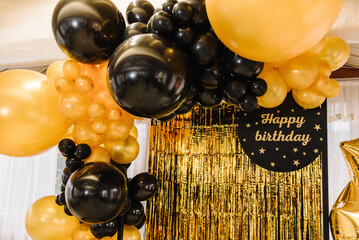 Arch decorated with black, brown, golden balloons and stars. Photo-wall decoration space, place...