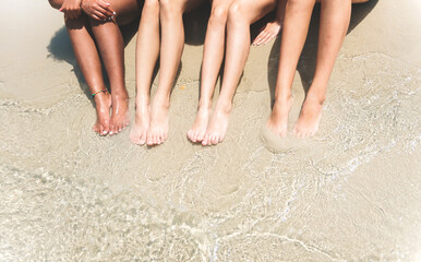 Close up leg of teenager lying on sand beach for relax and spending time together on summer,...