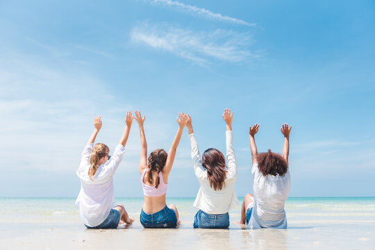 Group of diverse teenager friends sitting on the beach, spending time together on summer, Young girl enjoying with outdoor activity, Lifestyles on vacation concept.
