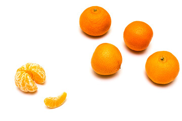 peeled tangerine on the background of unpeeled tangerines