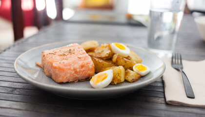 steamed salmon fillet with potato wedges and quail egg