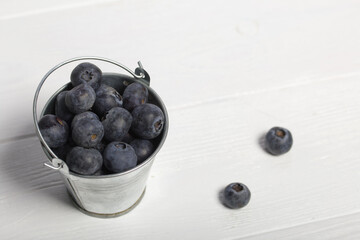 Large blueberries in a decorative bucket. International day without diets. On a white background. Close-up.
