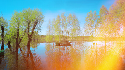 Boats Moored Near Trees That Standing In Water During Spring Flood Floodwaters. Scenic View Bright Sunbeams. Beautiful Spring Landscape With Reflection In River. Sun Shining With Sun Rays.