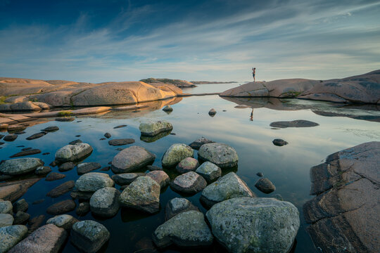Man Drinking Water in the Serene Reflecting Pool of Sweden's Archipelagos Gothenburg, orust