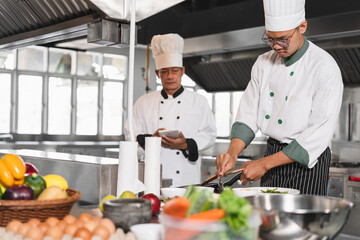 Asia teenager chef cooking with senior chef at kitchen background	