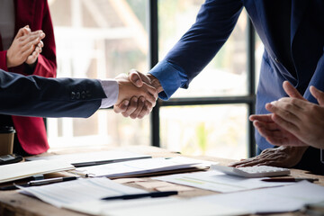 Close-up two business men holding hands, Two businessmen are agreeing on business together and shaking hands after a successful negotiation. Handshaking is a Western greeting or congratulation.