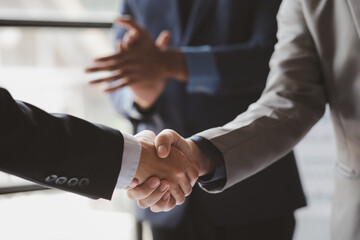 Close-up two business men holding hands, Two businessmen are agreeing on business together and shaking hands after a successful negotiation. Handshaking is a Western greeting or congratulation.