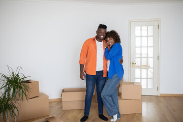 Fototapeta na wymiar Happy Black Couple Posing In Their New Home On Moving Day