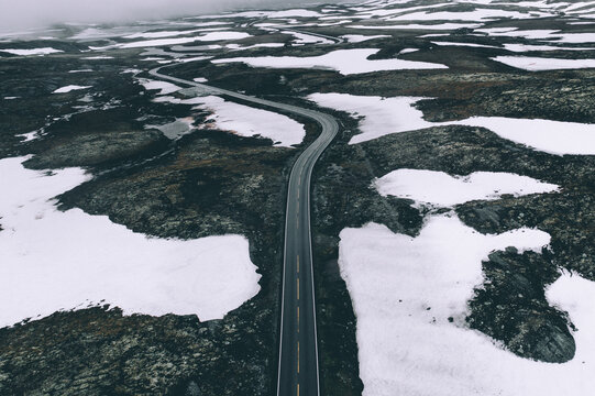 A Stunning Drone Photo of a Road Leading Through the Majestic Mountains of Stryn, Norway