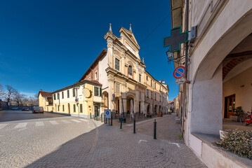 Fototapeta na wymiar Racconigi; Cuneo; Italy - Deconsecrated church of the confraternity of Santa Croce in Via Francesco Morosini and the arcades of the street