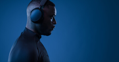 Serious black guy listening to song in headphones in studio