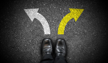 Fototapeta premium Black business shoes and two chalky arrows on asphalt - choice concept