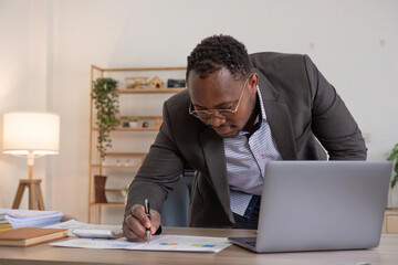 Accountant black man working on laptop and do document, tax, exchange, accounting and Financial advisor concept