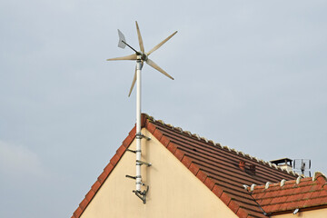 Éolienne individuelle fixée sur le pignon d'une maison.