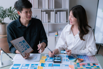 Fototapeta premium Man and woman ecommerce business workers using smartphone and Chart plan at the office.