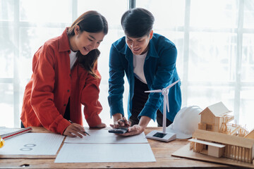 Fototapeta premium Happy young Asian couple enjoying in working time, watching on line chart. Smiling woman Happy.