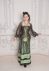 Beautiful young smiling woman wearing green medieval vintage Victorian Style dress