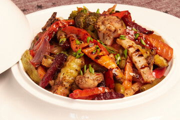 Grilled vegetables in a white plate in close-up. Vegetable mix for vegetarians: Bell peppers, zucchini, cauliflower, broccoli, onions, green beans, carrots, beets, celery