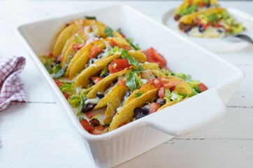 Tex mex taco casserole with ground beef, kidney beans. Gratinated with cheese and topped with fresh lettuce and tomatoes