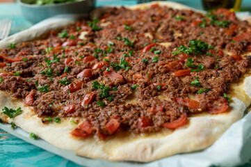 Turkish pizza or lahmacun with ground beef,  tomatoes, bell peppers, onions, garlic, and parsley,