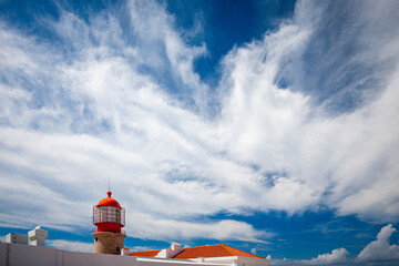 red lighthouse of the algarve portugal on blue sky