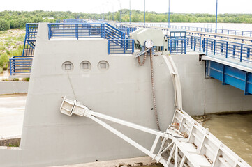 huge steel gates of a dam manipulated with three-layer chain