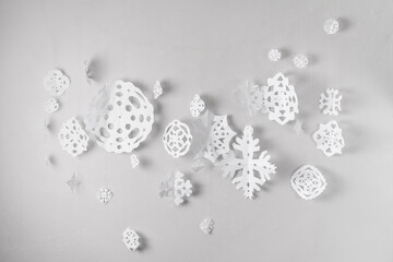 white paper snowflakes garland on grey wall