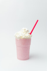 Vertical shot of a strawberry milkshake with a lot of whipped cream on top.