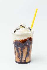 Chocolate tasty milkshake with whipped cream and a lot of topping on top.