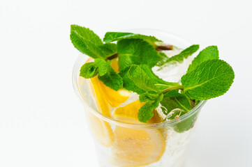Close up shot of a fresh lemonade in a to go plastic glass with mint leaves.
