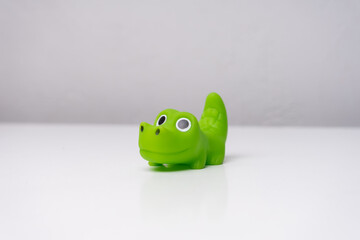 green toy crocodile on white table