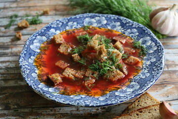 Traditional Ukrainian Borscht with Sour Cream. Red Beetroot Borscht with Dill, Bread, and Garlic on a Wooden Table.