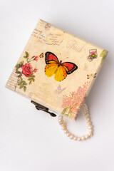 closed jewelry box with pearls on white background