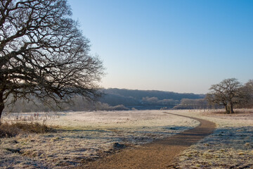 footpath through the English countryside with The River Hamble in the background on a cold frosty winter day