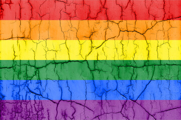 Flag of rainbow LGBT pride on cracked wall, textured background.