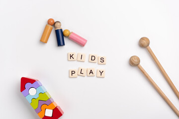 Flat lay of Montessori toys on white background. KIDS PLAY made with tile letters