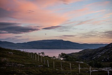 Fototapeta premium Mesmerizing sunrise over the hills and lake in Nothern Norway