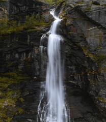 Fototapeta na wymiar Vertical shot of a flowing waterfall