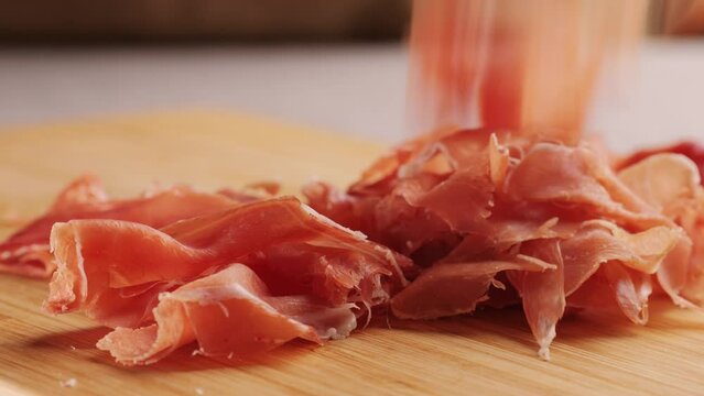 Jamon iberico tapas close up, chef cooking the best spanish ham pork tapas, cafe with traditional food.